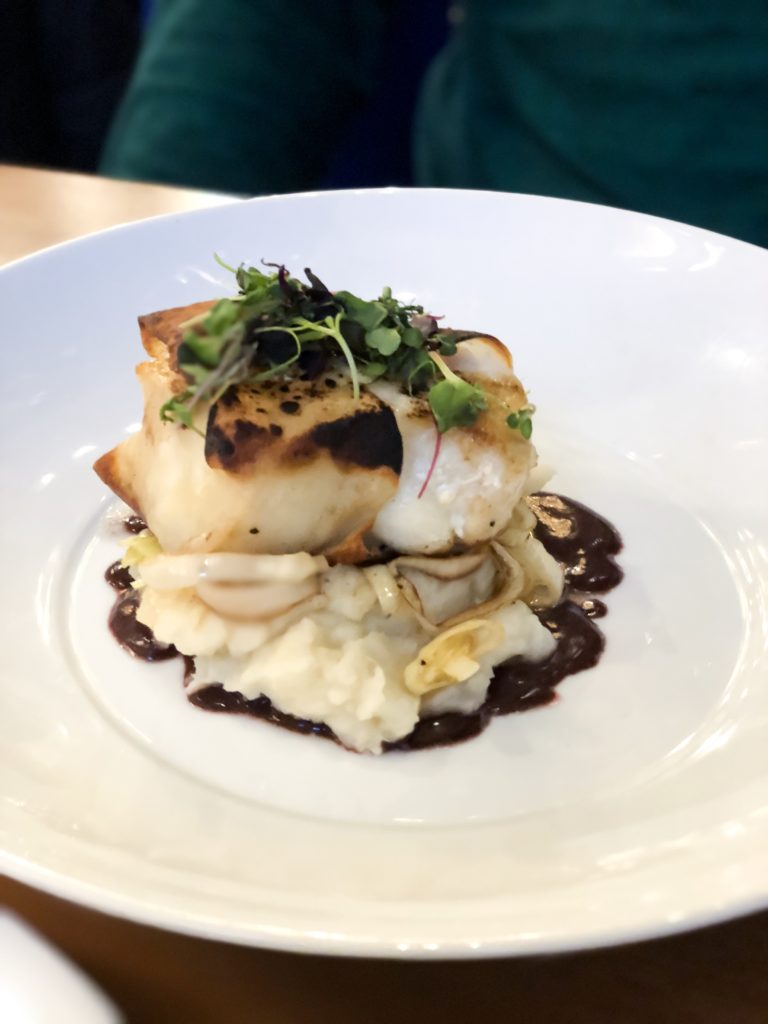 Fresh sea bass served on a bed of mashed potatoes with a red wine reduction