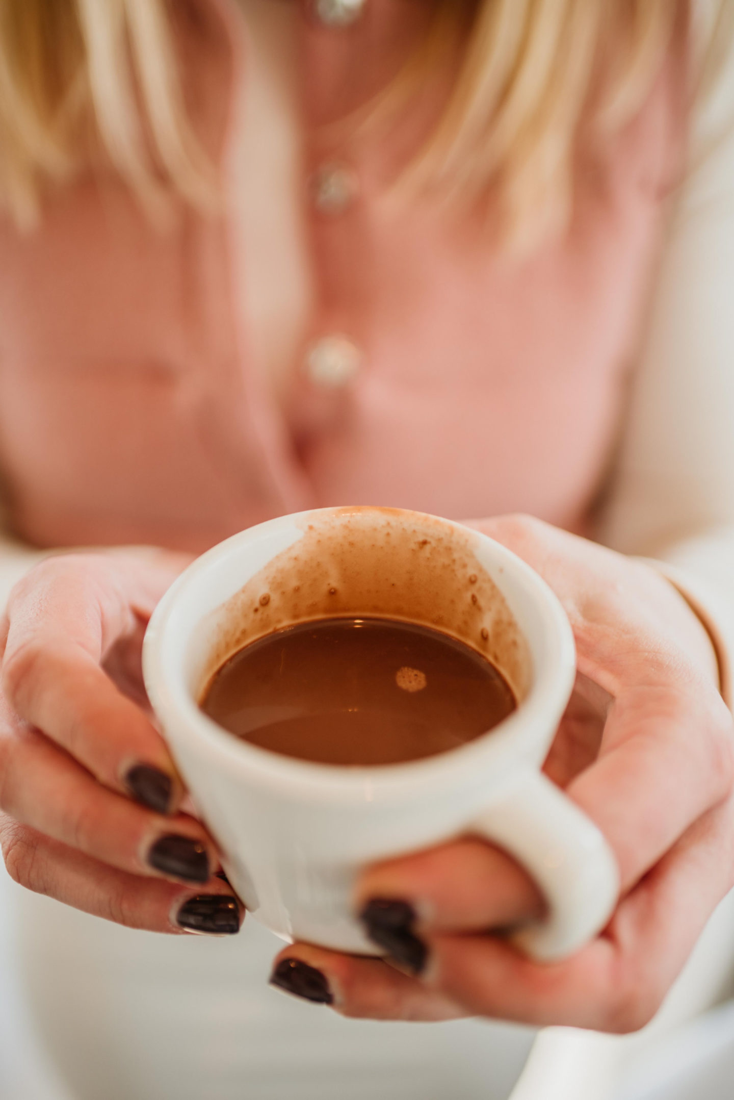 Girl Holding a White Cup of Mexican Hot Chocolate from Corto Lima in Lexington, Kentucky