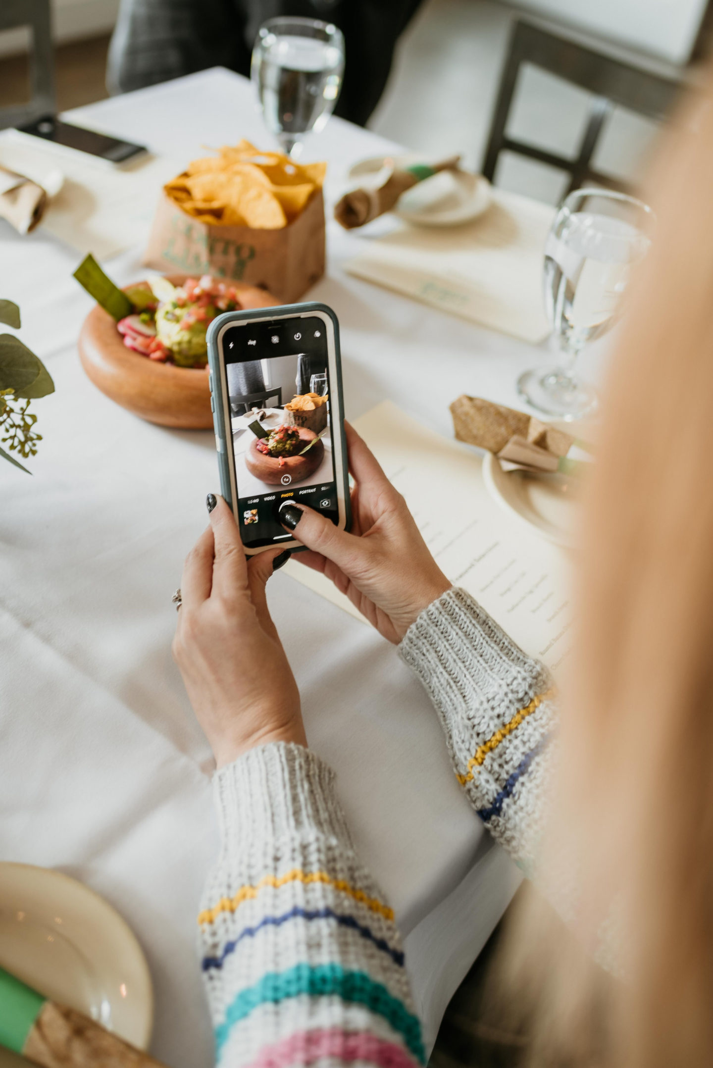 Picture of a girl taking a picture of guacamole with her iPhone X