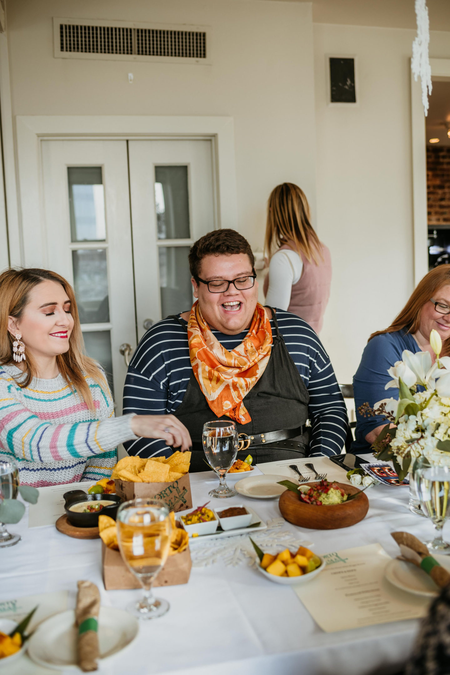 Girl and guy sitting in front of a table of food