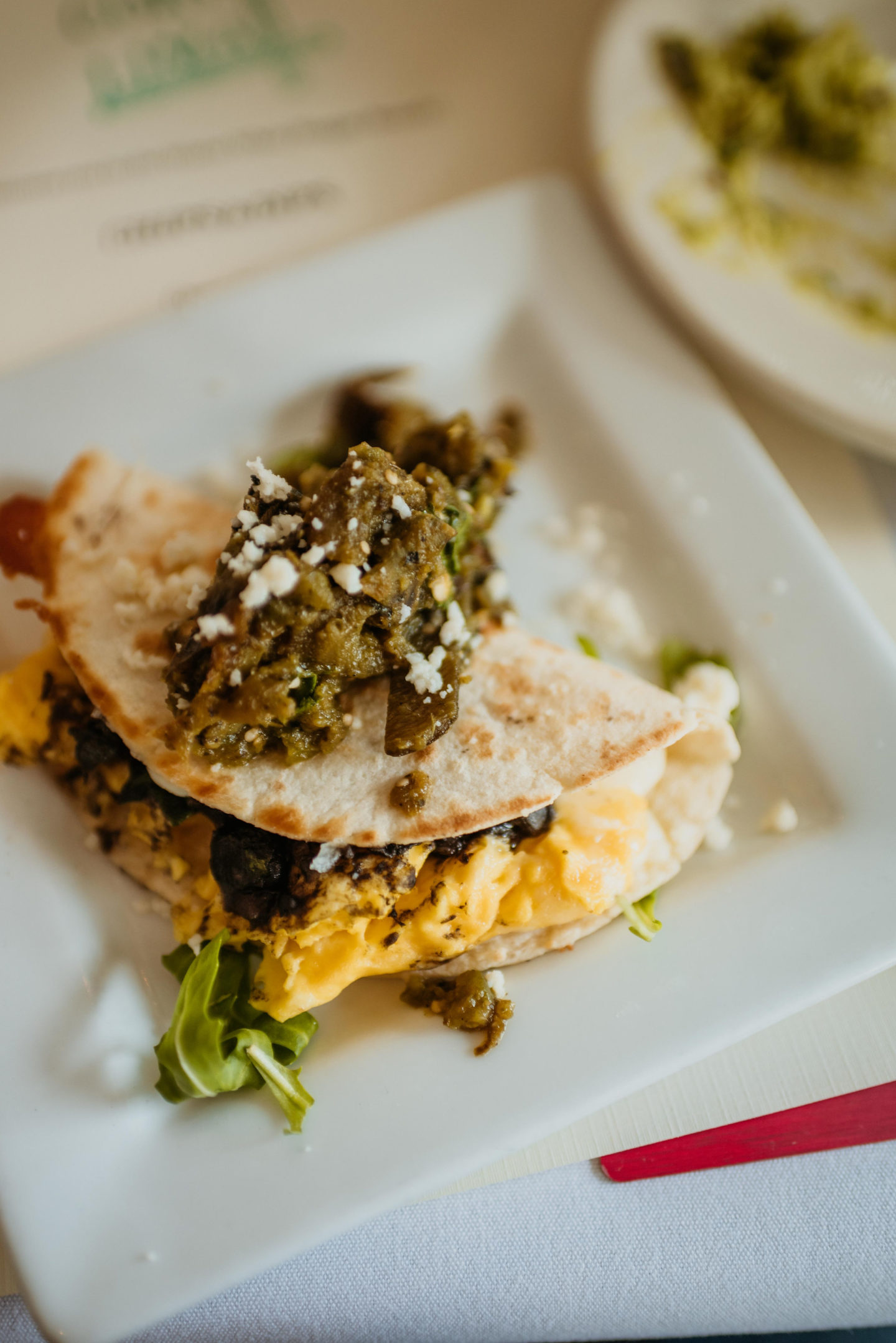 A plate of Huitlacoche Egg Quesadilla on a white square plate from Corto Lima in Lexington, Kentucky