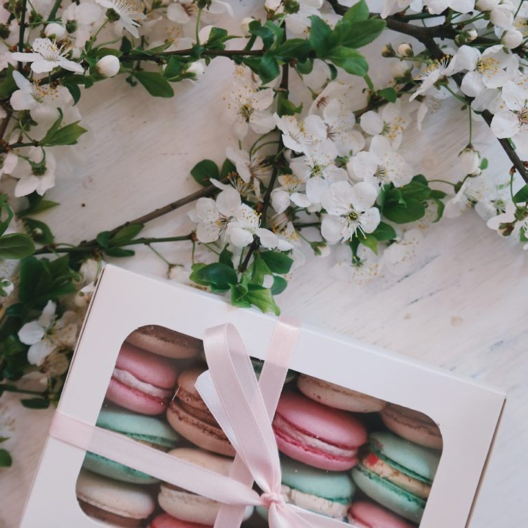 Colorful macarons in a box with a ribbon with flowers