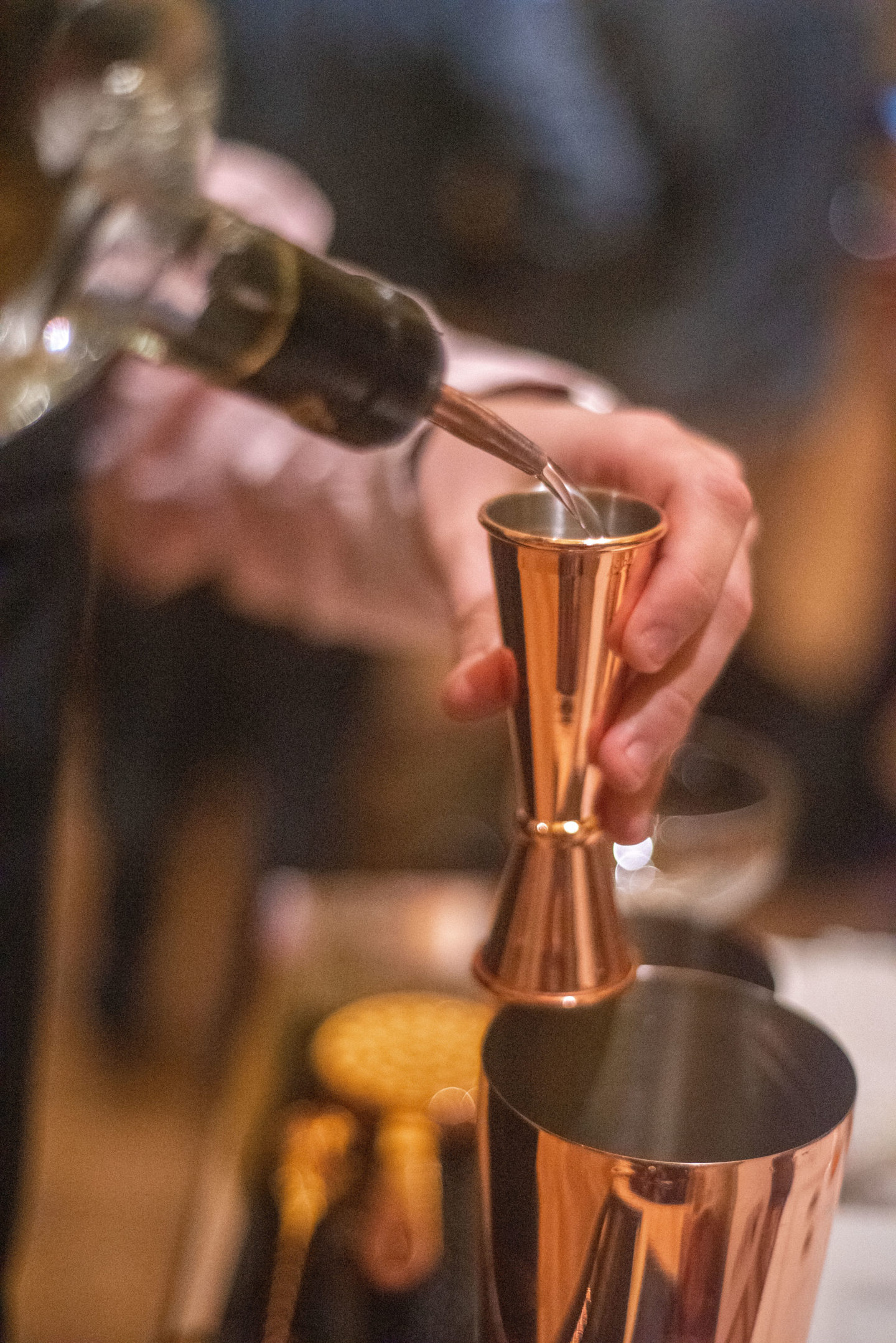 A pair of man's hands making a cocktail