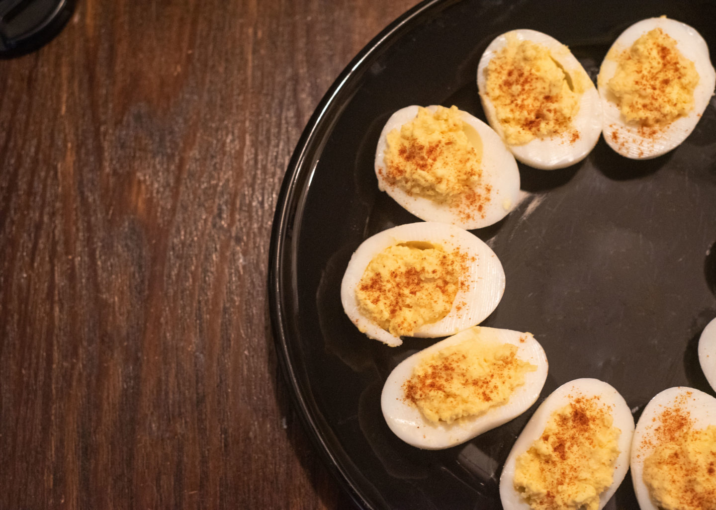 Spicy Deviled Eggs on a black plate