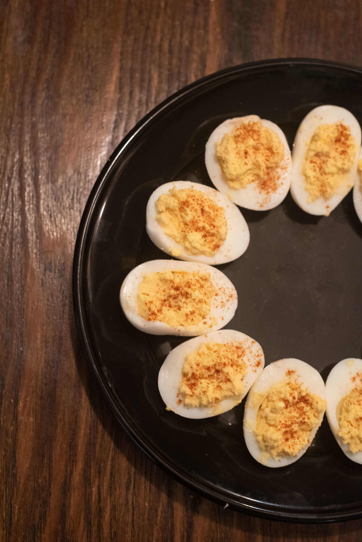 Spicy Deviled Eggs on a black plate