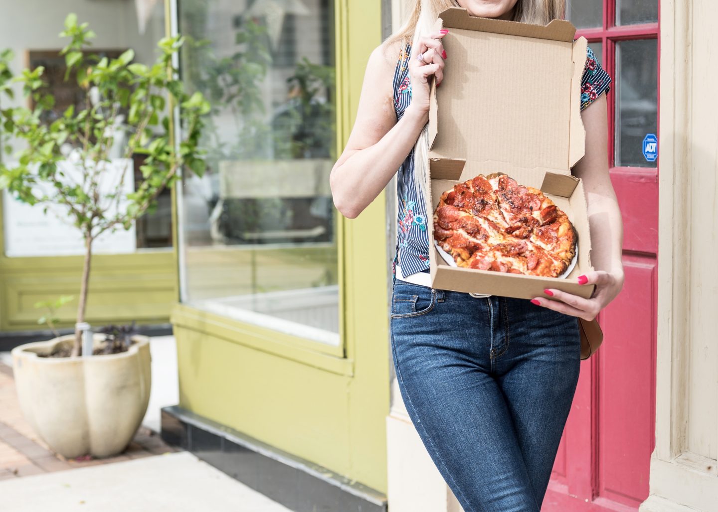 Girl holding a pepperoni pizza