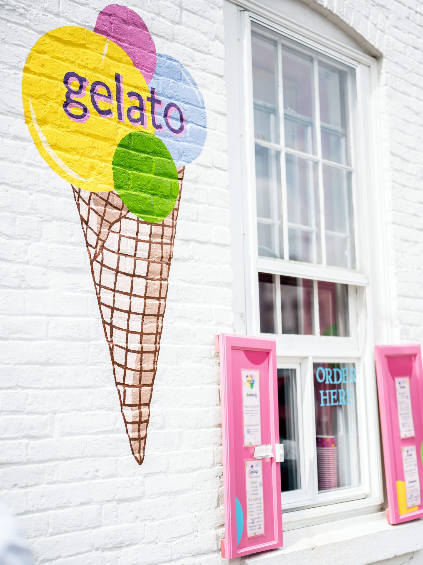 Colorful ice cream on a building that says Spotz Gelato