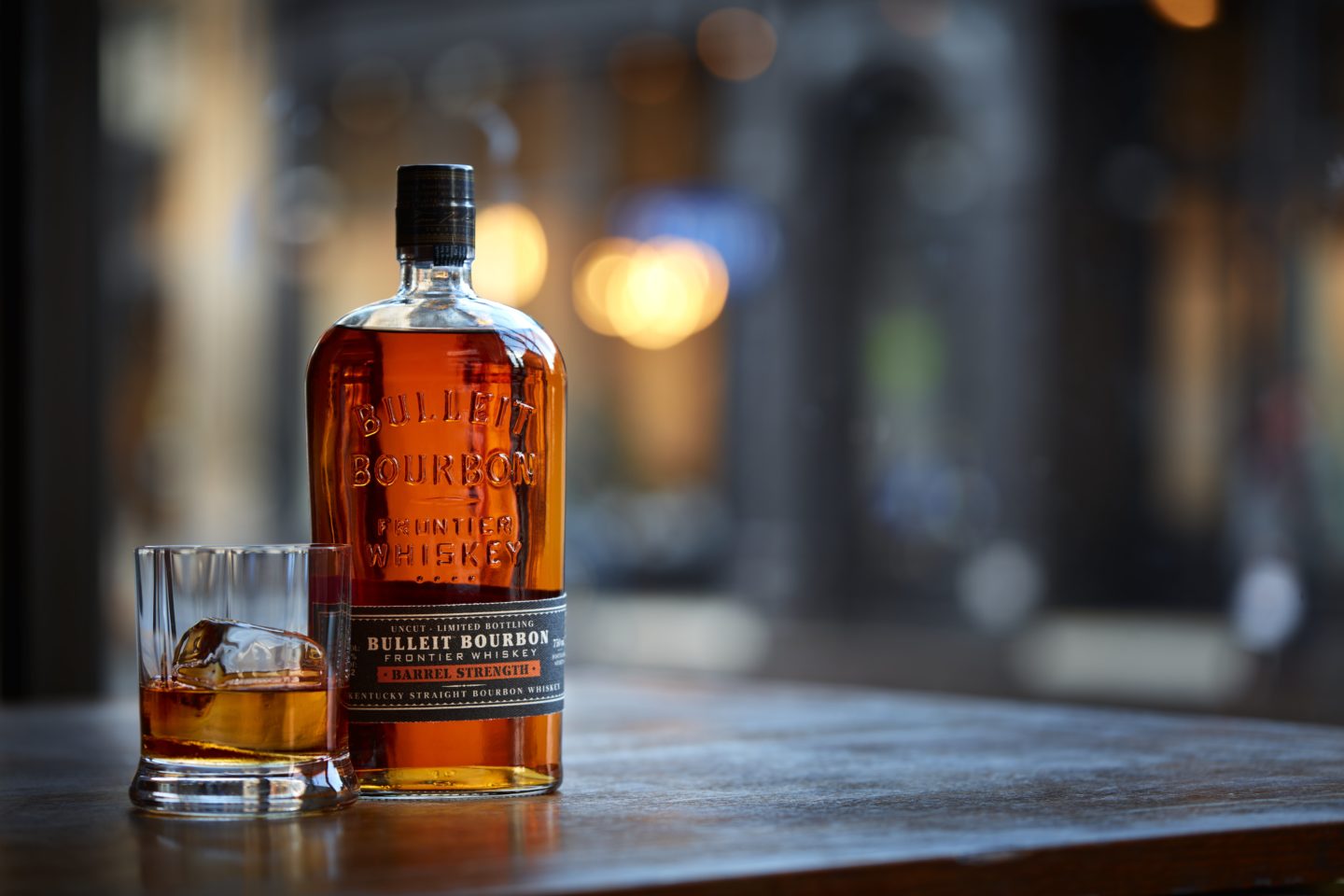 bourbon bottle and bourbon in a rocks glass