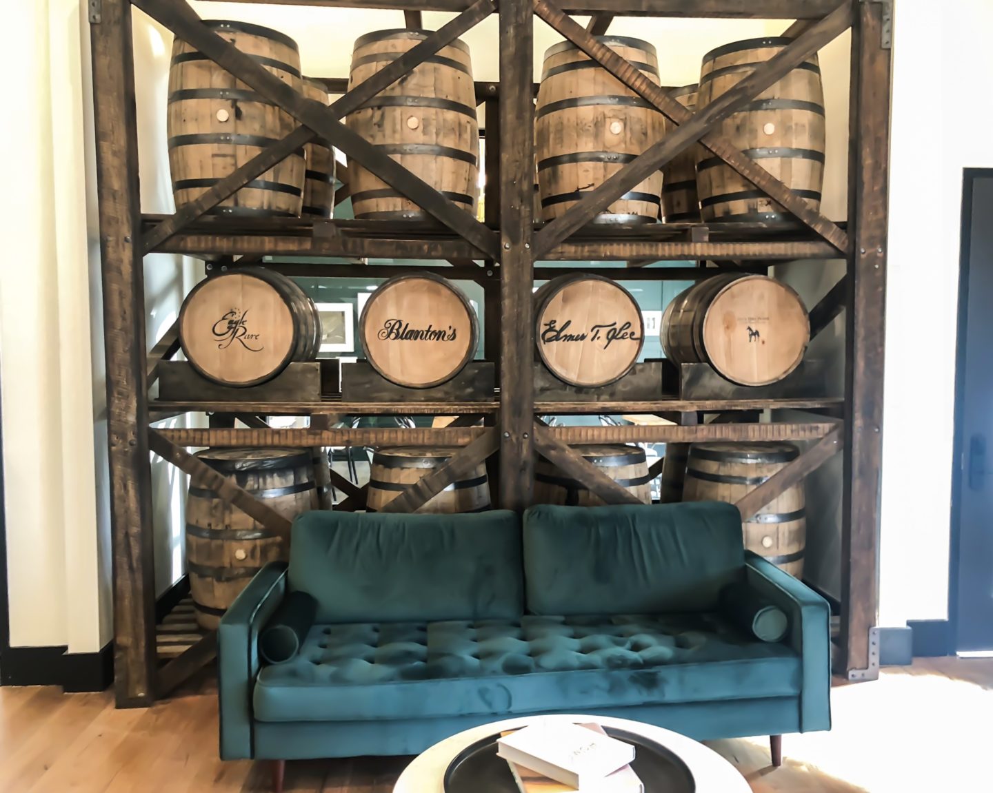 couch in front of a wall of bourbon barrels