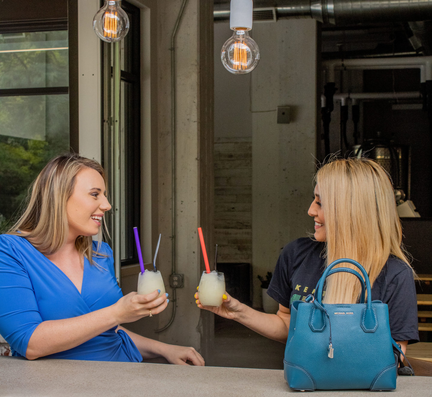 two girl drinking slushies outside