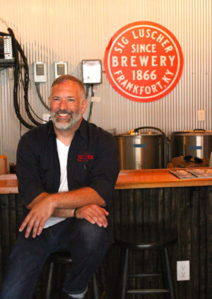 man smiling sitting on a stool